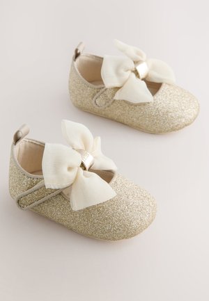 Guldglitter babysko med hvide stofsløjfer, runde tæer og elastiske stropper for en sikker pasform. Blødt inderfor for komfort.
