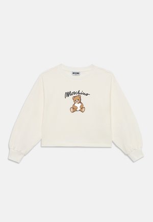 Sweatshirt court blanc à manches longues, arborant un ours en peluche brodé marron et le logo "Moschino" en noir au-dessus du design.