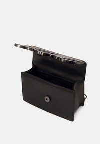 Borsa in pelle nera con una texture liscia, dotata di chiusura a scatto e manico strutturato in metallo. L'interno include slot per schede.