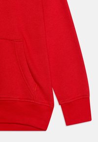 Felpa rossa con cappuccio, caratterizzata da una morbida texture, tasca a marsupio, polsini e vita a costine. Dettagli delle cuciture in un filo di contrasto.