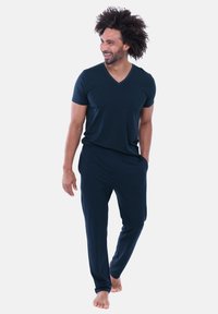 Herretøj i marineblåt til afslapning, bestående af en T-shirt med korte ærmer og V-hals samt bukser med elastisk linning, lavet af blødt og glat stof.