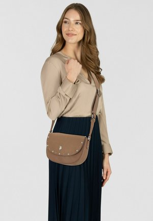 Torba na ramię z jasno-brązowej skóry o zaokrąglonym kształcie, ozdobiona srebrnymi ćwiekami i z akcentem logo. Regulowany pasek dla wszechstronności.
