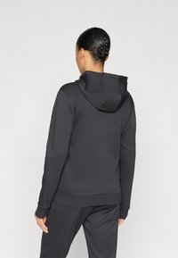 Μαύρο φούτερ με κουκούλα και μαλακή υφή, με τσέπη καγκουρό και ριμπ μανσέτες και τελείωμα. Η πίσω πλευρά είναι απλή, χωρίς διακοσμήσεις.