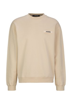 Beige sweatshirt met lange mouwen, geribde boorden, ronde hals en klein rechthoekig Jacquemus merklabel op de borst.