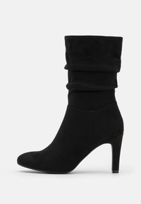 Bottine en daim noir avec tige froissée, bout pointu et talon aiguille. La texture est lisse, offrant un aspect doux.