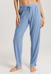 Lichtblauwe loungebroek van zachte stof, met een elastische tailleband met trekkoord en zijsplitten aan de zoom.