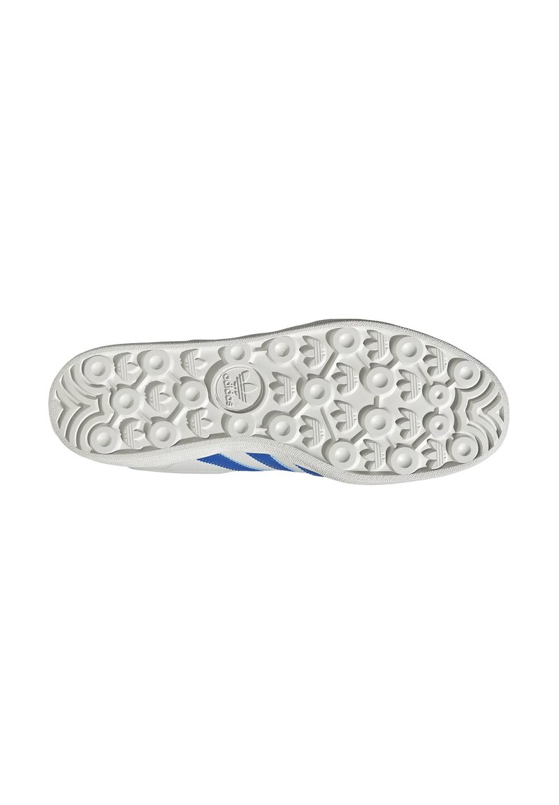 Semelle d'une basket blanche avec un motif texturé et des rayures bleues. Présente un logo au centre, conçue pour l'adhérence et le confort.