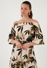 Off-the-shoulder dress with a floral print in beige, brown, and dark blue. Features 3/4 sleeves and textured fabric with a fitted waist.