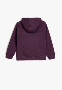 Lila huvtröja med en mjuk tygtextur. Har en känguruficka samt ribbade muddar och nederkant. Bakifrån visas en enkel design.