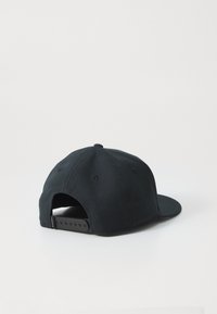 Sort snapback-cap vist fra bagsiden med justerbart plastspænde og seks-panel stofkonstruktion på en hvid baggrund.