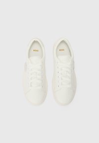 Sneaker bianche con tomaia in pelle liscia, punta rotonda, lacci piatti, suola in gomma beige e logo dorato "BOSS" sulla soletta.