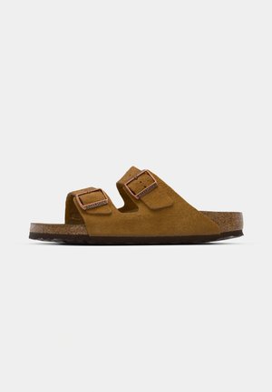 Sandali in suede marrone con due fibbie regolabili, fondo in sughero e suola in gomma testurizzata. Design aperto e facile da indossare per il massimo comfort.