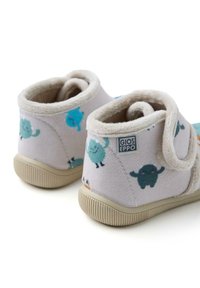 Zapatillas infantiles de color gris claro con forro de felpa, que presentan personajes de dibujos animados coloridos. Cinta de velcro y suela de goma texturizada.