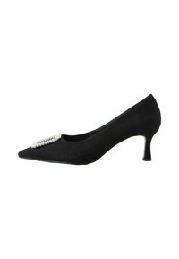Escarpin en suède noir avec un bout pointu et un petit talon épais. Présente une boucle décorative avec des strass sur la partie des orteils.