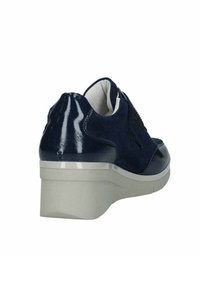 Scarpa blu navy con finitura lucida e materiale morbido, dotata di una suola a cuneo grigio chiaro e dettagli testurizzati sui lati.
