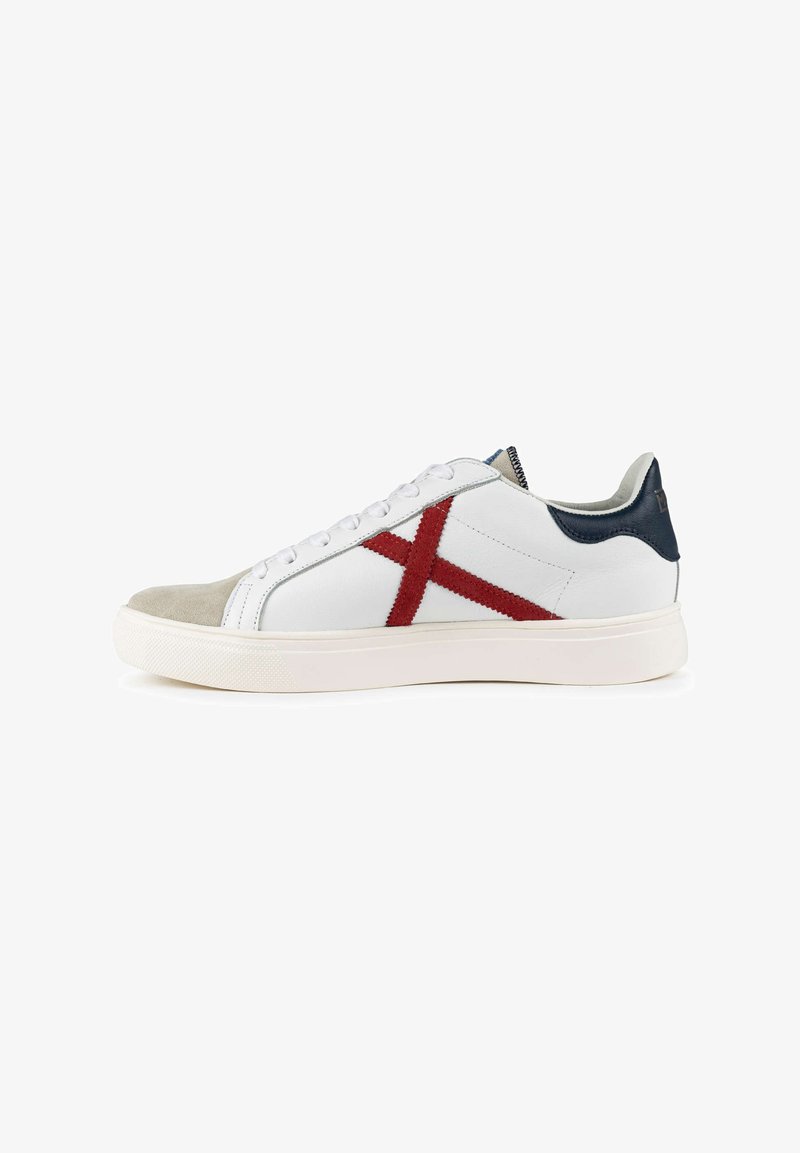 Witte leren sneaker met een rood gestructureerd kruisontwerp, grijze suède neuzenkap, marineblauw hielaccent en een witte rubberen zool. Vetersluiting.