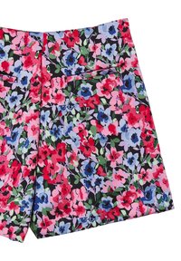 Blumige Shorts aus einem Stoff mit schwarzem Hintergrund. Sie haben leuchtend rote, blaue und pinke Blumen sowie grüne Blätter und ein Detail mit einer Gesäßtasche.