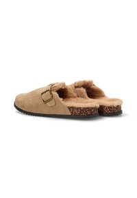 Zuecos de gamuza beige con un interior esponjoso, correa ajustable con un cinturón metálico y suela de corcho texturizada. Diseño casual de fácil puesta.