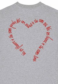 Szara bawełniana koszulka z czerwonym wzorem serca, w którym spiraluje tekst. Czcionka jest pisana kursywą, co podkreśla atrakcyjność wizualną.