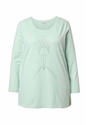 Camiseta de manga larga en verde menta con escote redondeado, que presenta un gráfico lineal y texturizado de una figura con vestido.