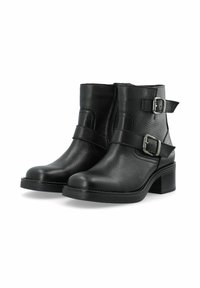 Černé kožené kotníkové boty s texturovaným povrchem, vybavené dvěma nastavitelnými stříbrnými sponami a nízkým blokovým podpatkem. Klasický design a tvar.