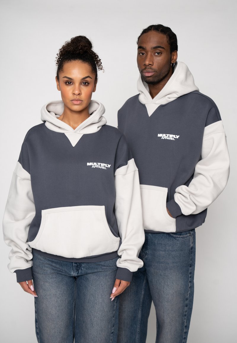 Hanorace în gri închis cu accente gri deschis, prevăzute cu buzunar frontal și glugă cu șnur. Logo imprimat pe zona pieptului. Croială casual.