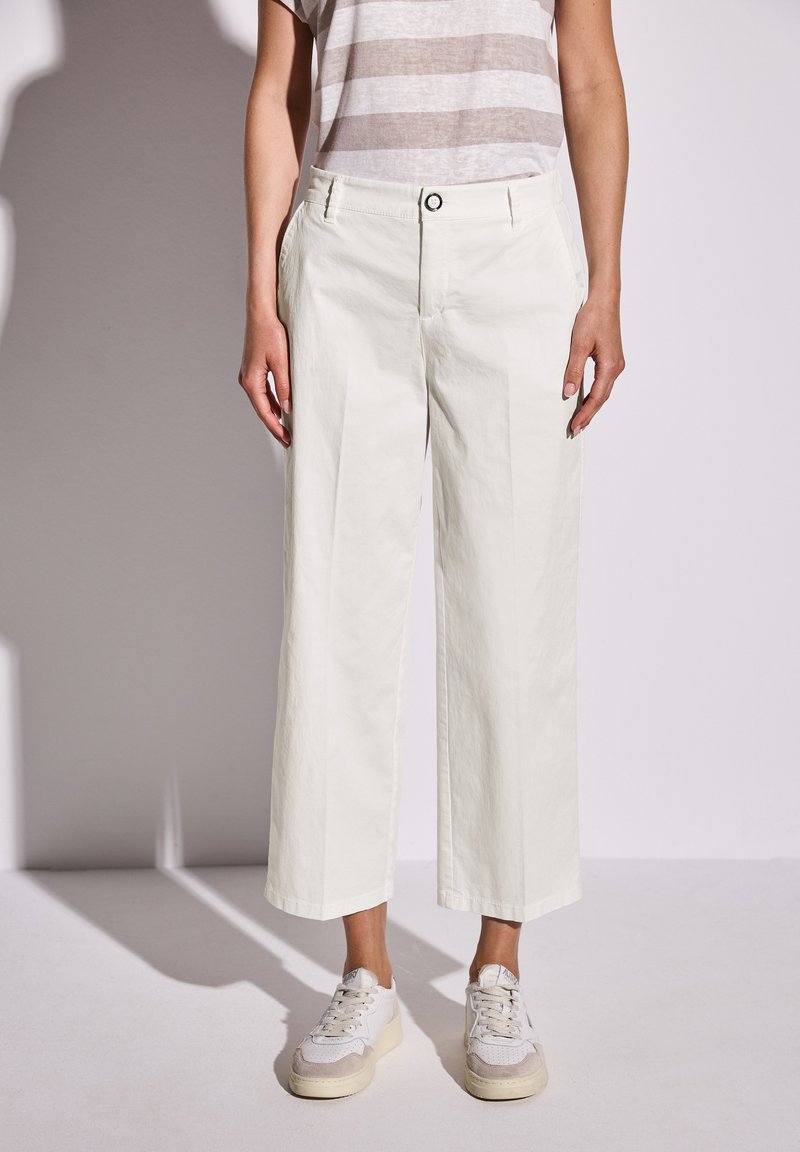 Wide-leg, off-white cotton pants with a smooth texture, featuring a button closure, side pockets, and subtle creases for detail.