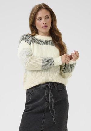 Lightweight knitted sweater in cream with gray striped accents. Round neckline, ribbed cuffs and hem. Paired with a black denim skirt.