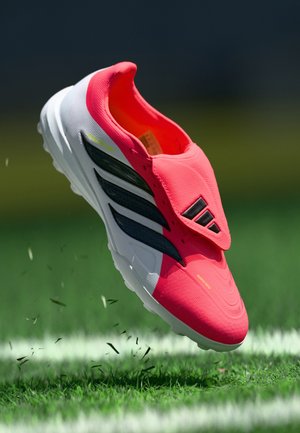 Rosa Sportschuhe mit glatter Textur, die schwarze Streifen und eine weiße Sohle aufweisen. Das Design umfasst eine abgerundete Spitze und einen sicheren Obermaterialüberzug.