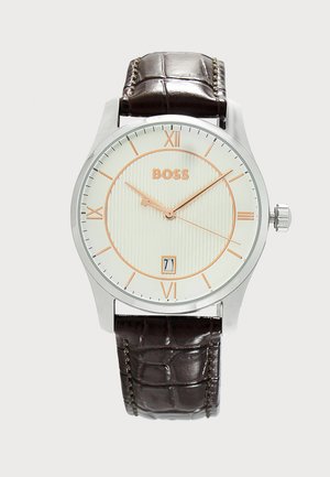Okrągły srebrny zegarek na rękę z białą tarczą, złotymi cyframi rzymskimi i wskazówkami, brązowym skórzanym paskiem, logo "BOSS" oraz wyświetlaczem daty pokazującym 7.