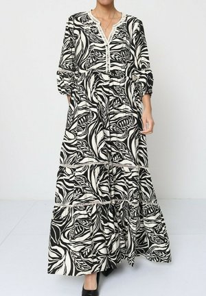 Robe maxi en imprimé floral noir et blanc, avec un décolleté en V, des manches trois quarts et un tissu texturé à volants.