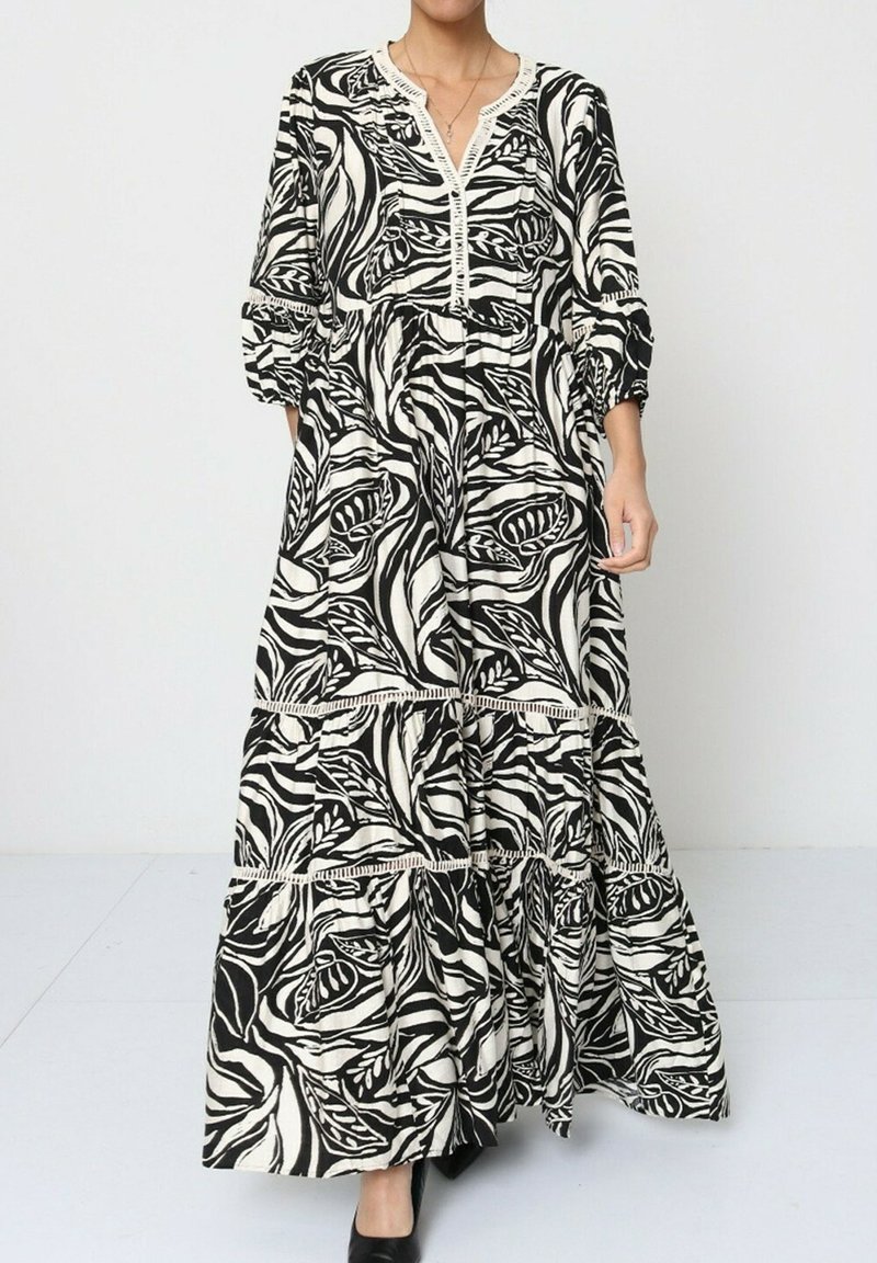 Robe maxi en imprimé floral noir et blanc, avec un décolleté en V, des manches trois quarts et un tissu texturé à volants.