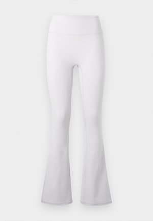 Valged kõrge vöökohaga jooga püksid, lehvikukujuliste sääreosadega ja siledast kangast, ühtlasel helel taustal.