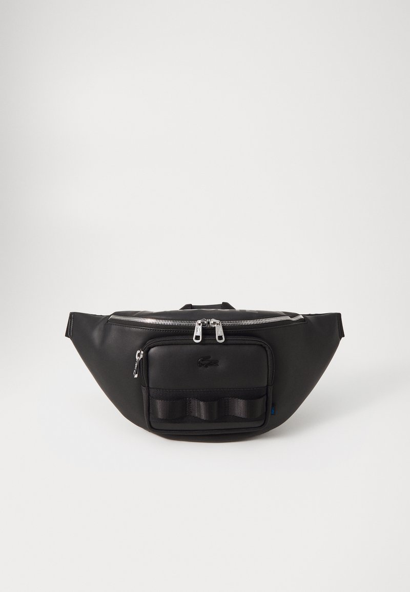 Sac banane noir avec compartiments zippés, matériau synthétique lisse, design courbé et une poche avant avec un detailing texturé.