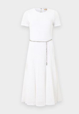 Robe midi blanche à manches courtes en tissu texturé avec une fine ceinture chaîne argentée portée lâchement à la taille.