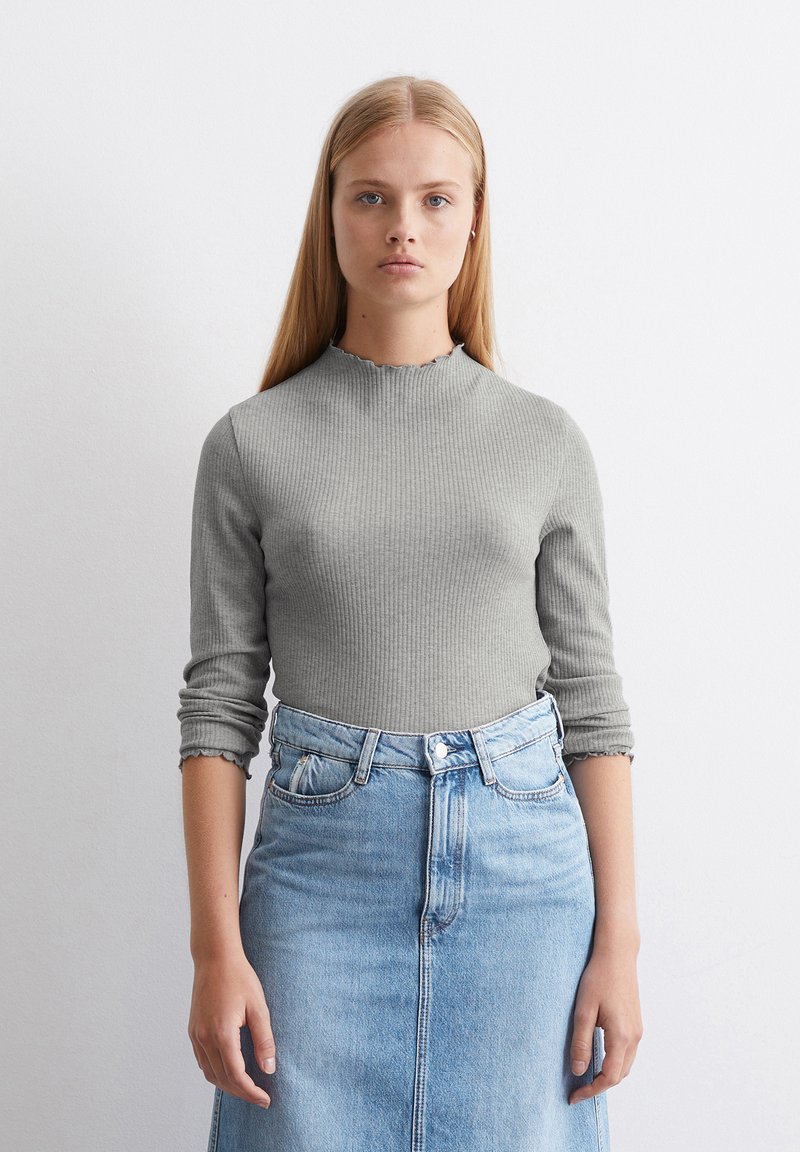 Grijze geribde langetermijntop met een golfvormige halslijn, gecombineerd met een lichtblauwe spijkerrok met hoge taille. Glad textuur, aansluitend ontwerp.