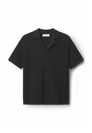 Zwart shirt met korte mouwen, voorzien van een gestructureerd wafelpatroon, een notch-kraag en een vooraan sluiting met knopen. Geen zichtbare branding.