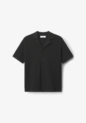 Lühikeste varrukatega must särk, millel on tekstureeritud vahvliraami muster, sälguga krae ja esine nööpide kinnitamine. Ei mingeid nähtavaid brändimärke.