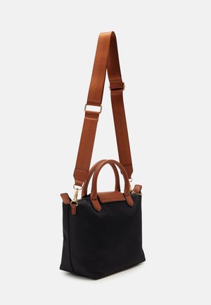 Sac à main rectangulaire noir avec des poignées marron et une bandoulière large réglable sur un fond clair.