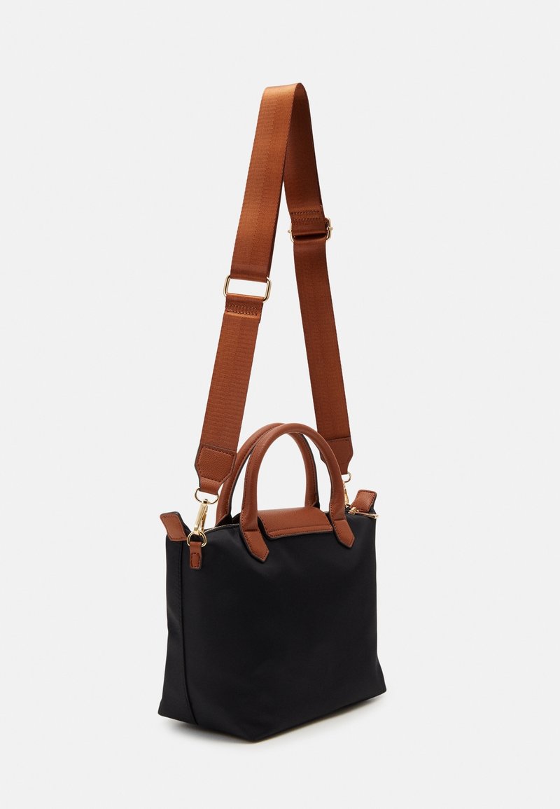 Sac à main rectangulaire noir avec des poignées marron et une bandoulière large réglable sur un fond clair.