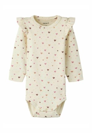 Kremowy kombinezon niemowlęcy w różowe i brązowe serduszka, z długimi rękawami, falbankami na ramionach oraz zatrzaskami u dołu.
