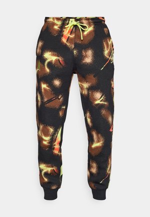 Black sweatpants with a vibrant abstract pattern in orange and green hues. Features an elastic waistband with a neon green drawstring and ankle cuffs.