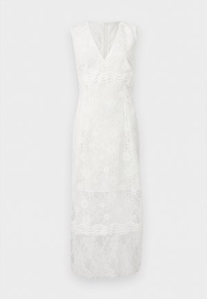 Robe blanche sans manches en dentelle avec décolleté en V, taille cintrée, motifs floraux et ourlet en dentelle transparente s'étendant sous le genou.