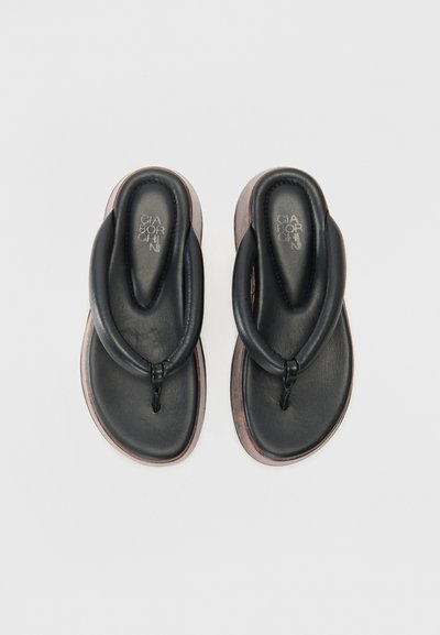Musta nahkainen flip-flop-malli, jossa on solmittu hihnasuunnittelu, pehmeä pohja ja kontrastiväriset ruskeat pohjarajat. Sileä pinta.
