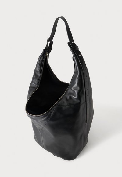 Sac à bandoulière en cuir noir avec une longue bandoulière, une fermeture éclair argentée et un intérieur ouvert et spacieux.