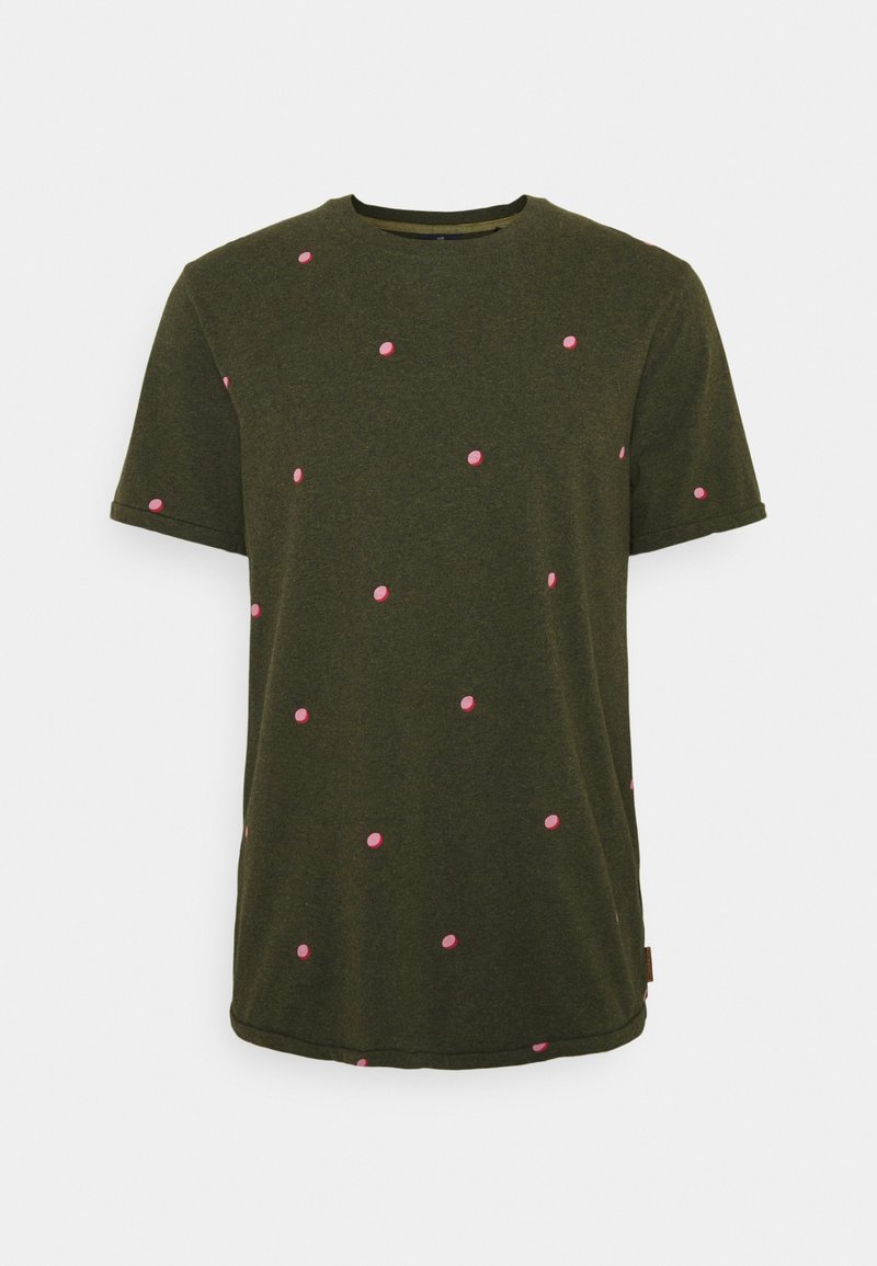Olivengrøn t-shirt med korte ærmer, prydet med spredte lyserøde polka prikker. Den er lavet af blødt stof, har en rund halsudskæring og en lige kant.