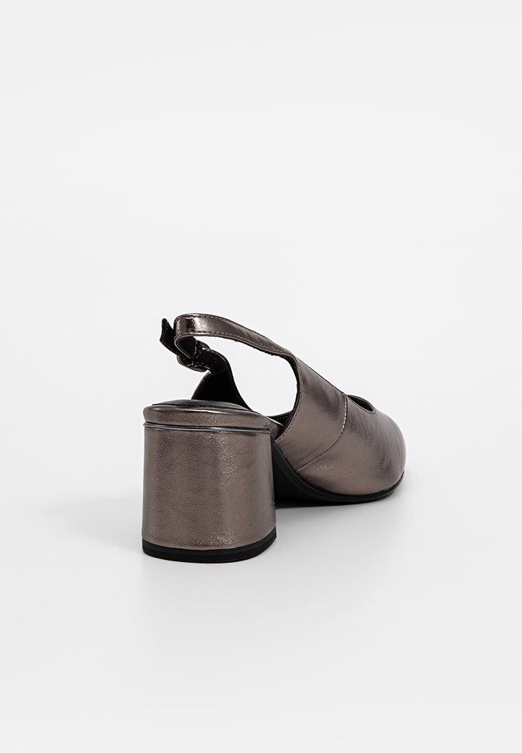 Chaussure slingback en bronze métallique avec un bout arrondi, des côtés ouverts et un talon épais. Texture lisse et éclat subtil. Détail de sangle ajustable.