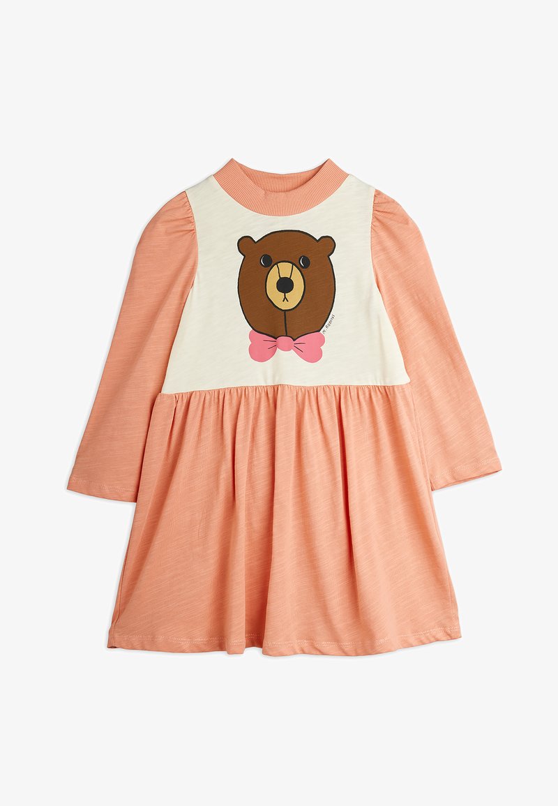 Vestido de mangas longas com parte inferior coral e parte superior creme, apresentando uma ilustração de um urso com uma laço rosa. Feito de um tecido macio e texturizado.