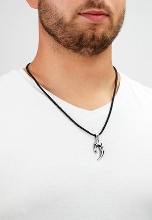 Schwarze geflochtene Halskette mit einem silberfarbenen Anhänger in Form einer stilisierten Klaue, entworfen für einen engen Sitz um den Hals.