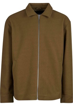 Veste zippée marron avec col mandarin, fabriquée dans un matériau doux. Comprend des poches latérales et un design épuré et minimal.